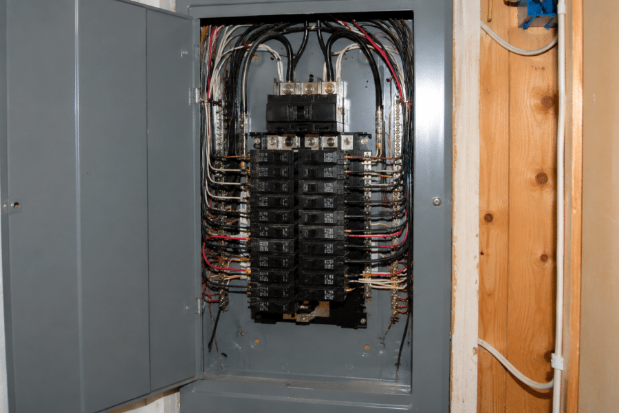 Open residential electrical panel showing circuit breakers and branch wiring during a home inspection