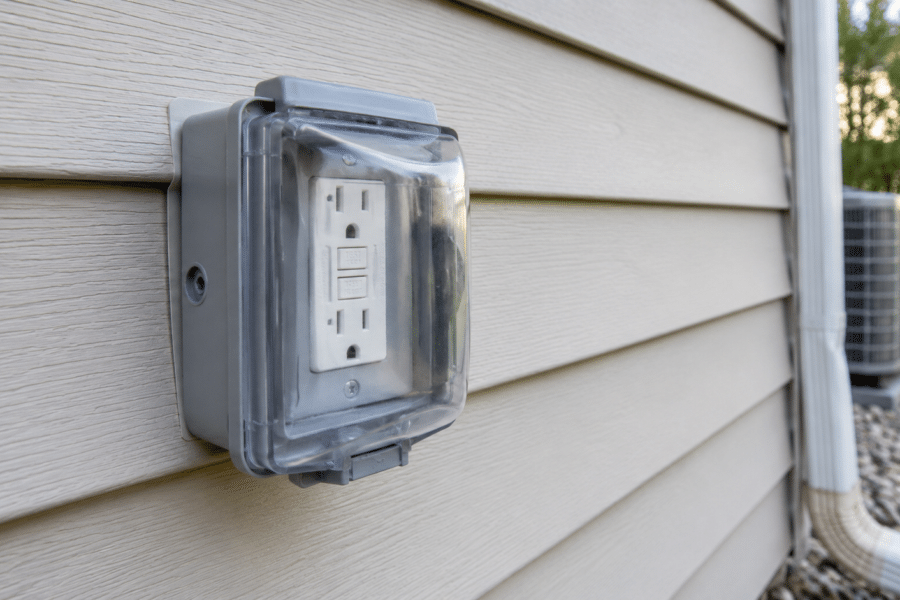 Exterior GFCI receptacle with an in-use weatherproof cover mounted on residential siding